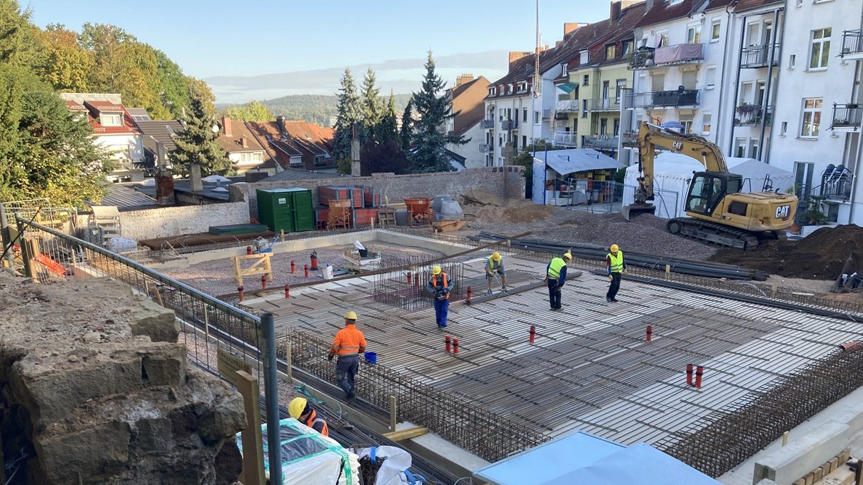 Blick auf die Baustelle von oben mit Arbeitern beim Fundamentbau