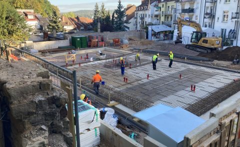 Blick auf die Baustelle von oben mit Arbeitern beim Fundamentbau